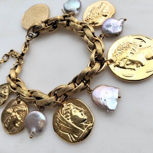 May include: Gold-toned charm bracelet featuring a braided chain design. The bracelet is adorned with coin-shaped charms and irregularly shaped pearls. The charms depict classical figures. The bracelet is a statement piece.