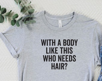 May include: A light gray t-shirt with the text "WITH A BODY LIKE THIS WHO NEEDS HAIR?" is paired with blue jeans and white sneakers. The shirt is knotted at the waist, and the sneakers have red accents.