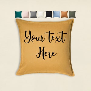 May include: A mustard yellow throw pillow with black text that reads "Your text here".