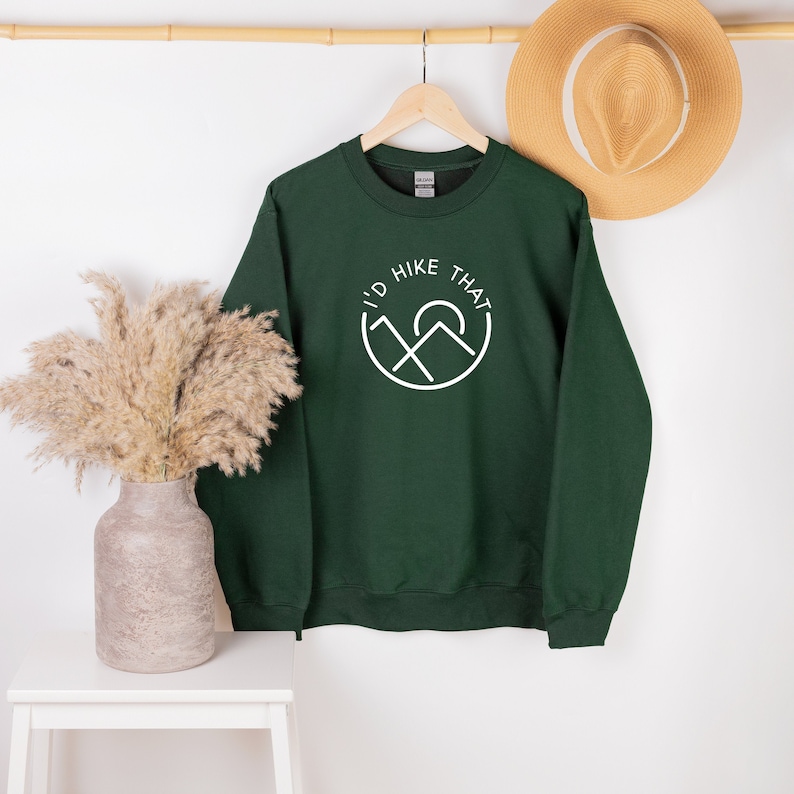 May include: A dark green sweatshirt with a white graphic that says "I'd Hike That" with a mountain and sun design.