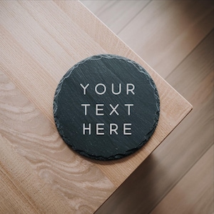 May include: A black slate coaster with the text "YOUR TEXT HERE" in white lettering.