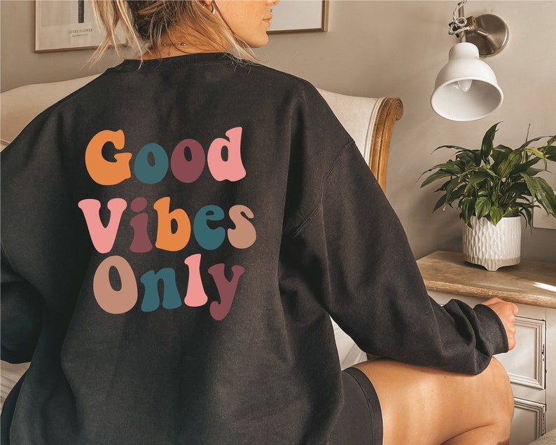 May include: Black sweatshirt with a colorful "Good Vibes Only" graphic on the back.