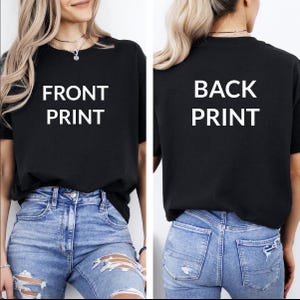 May include: A black t-shirt with "FRONT PRINT" on the front and "BACK PRINT" on the back. The t-shirt is being worn by a person with blue jeans.