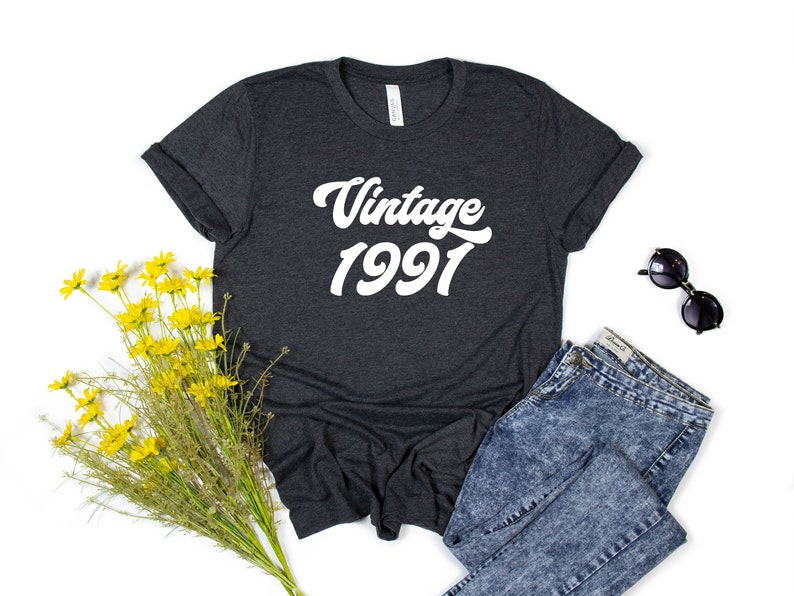 May include: A dark gray t-shirt with white text that reads "Vintage 1991".