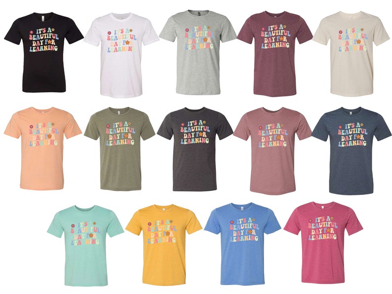 May include: A set of 12 t-shirts in various colors featuring the text "It's a beautiful day for learning" in a colorful retro font with flower accents.