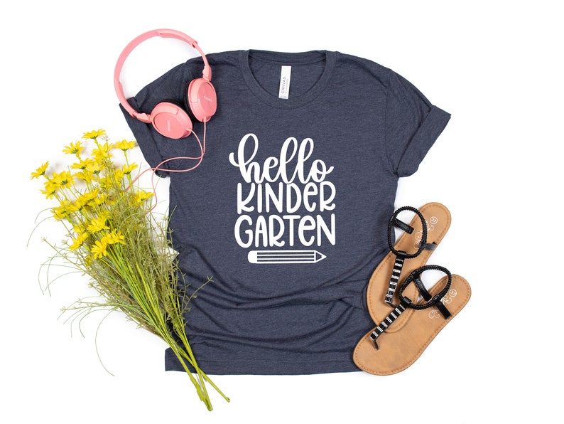May include: A navy blue t-shirt with the text "hello kindergarten" in white lettering and a white pencil graphic.
