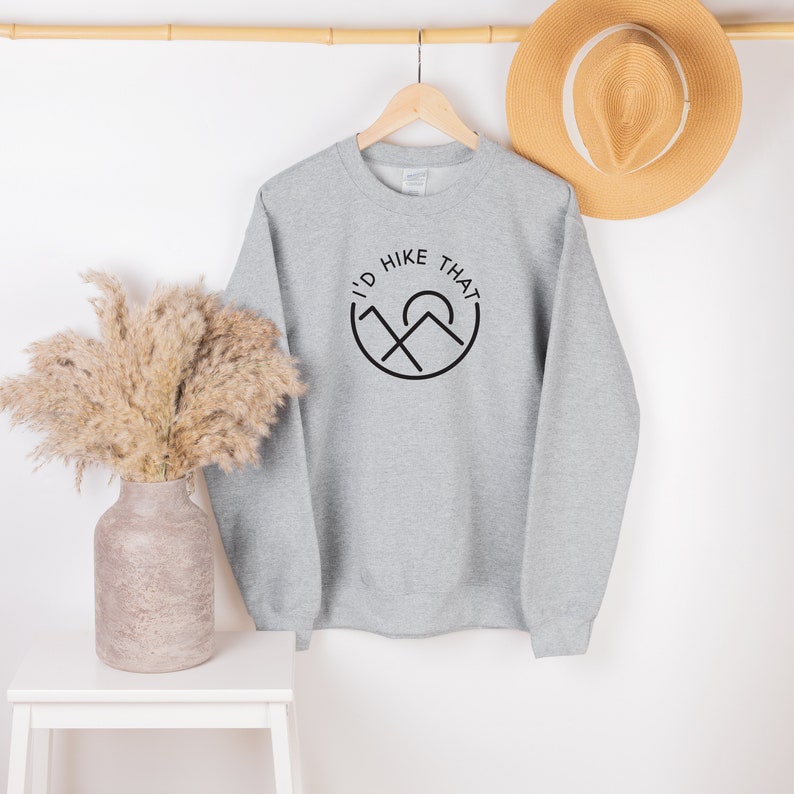 May include: Gray sweatshirt with a black graphic that says "I'd Hike That" with a mountain and sun design.