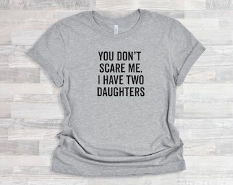 May include: Gray t-shirt with the text "You don't scare me. I have two daughters" printed in black.