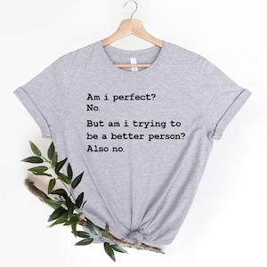Puede incluir: Camiseta gris con texto negro que dice: "Am i perfect? No. But am i trying to be a better person? Also no."