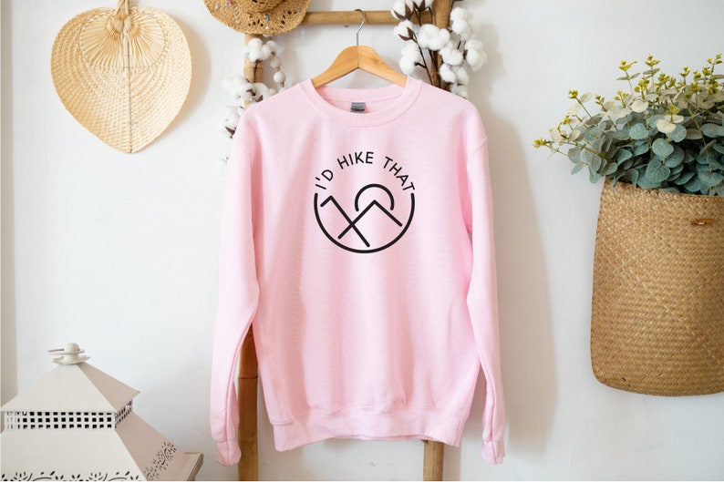 May include: A pink sweatshirt with a black graphic that says "I'd Hike That" with a mountain and sun design.