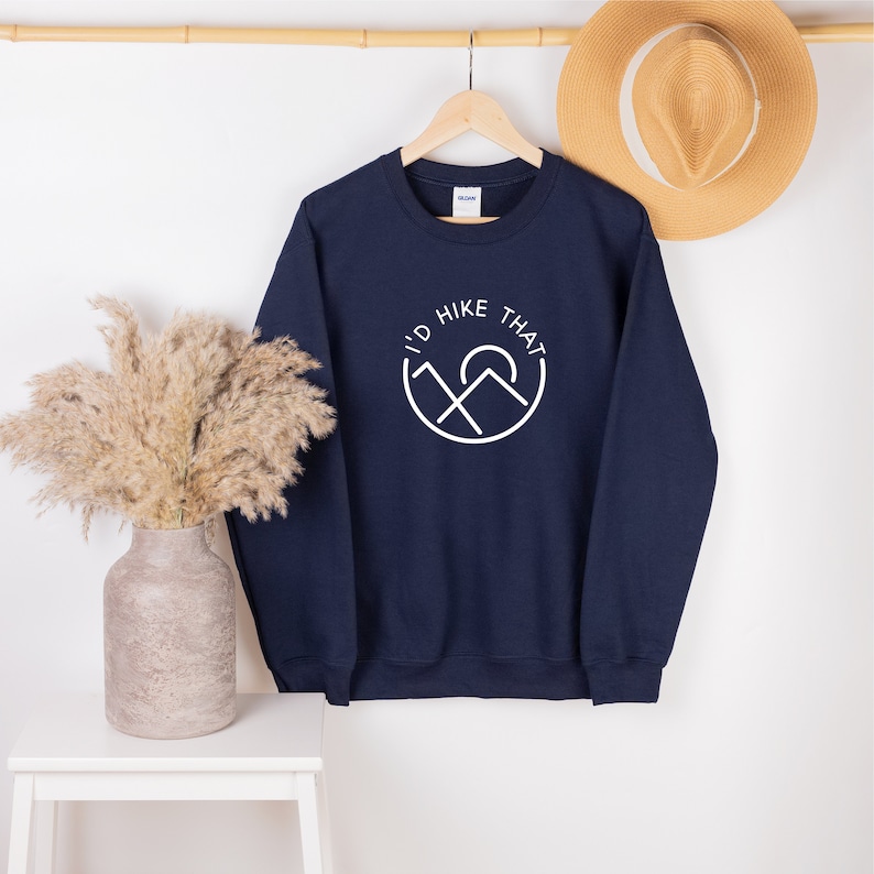 May include: Navy blue sweatshirt with a white graphic of mountains and a sun with the text "I'd Hike That".
