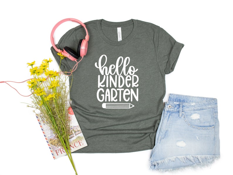 May include: A dark green t-shirt with the text "hello kindergarten" in white lettering and a white pencil graphic.