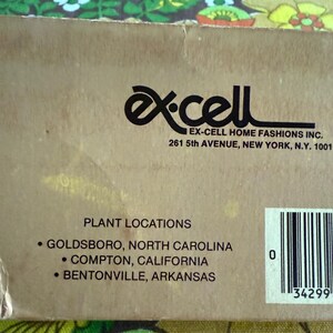 May include: A close-up of a cardboard box with the "Ex-Cell Home Fashions Inc." logo and address. The text "Plant Locations" is visible, listing Goldsboro, North Carolina; Compton, California; and Bentonville, Arkansas.