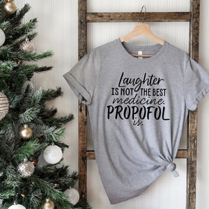 May include: A gray t-shirt with black text that reads "Laughter is not the best medicine. Propofol is."