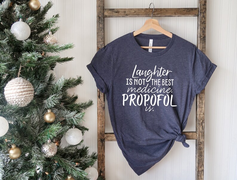 May include: A dark blue t-shirt with white text that reads "Laughter is not the best medicine. Propofol is."