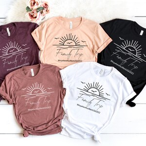 May include: Five t-shirts with a sunset graphic and the text "Family Trip #AnywhereYouWantUSA2022" printed on them. The shirts are in various colors, including maroon, beige, black, and white.