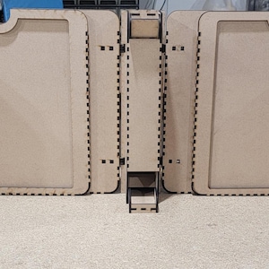 Puede incluir: Un expositor de madera con cinco compartimentos abiertos, cada uno con un borde negro. El expositor está hecho de madera marrón claro y tiene un diseño sencillo.