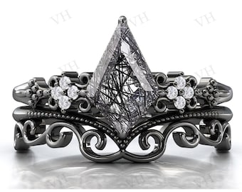 Op de afbeelding: Zwarte en witte verlovingsring met een grote, heldere, gefacetteerde edelsteen gezet in een zwarte metalen band. De band is versierd met ingewikkelde krulwerk en kleine, heldere edelstenen.