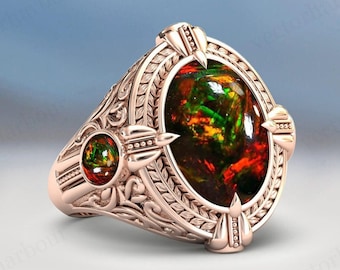 May include: A gold ring featuring a large oval-shaped gemstone set within an intricate ornate design. The gemstone is a multi-coloured opal with shades of green, red, and orange.