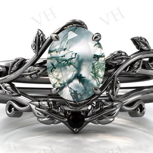 Puede incluir: Un anillo de plata con una piedra preciosa de ágata verde y blanca engastada en un diseño de hojas.