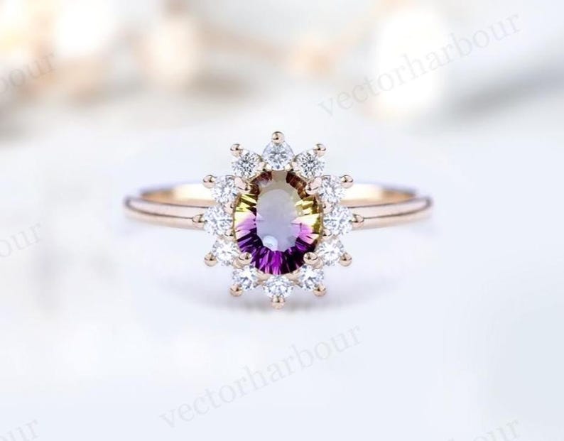 Puede incluir: Un anillo de compromiso de oro rosa con una gran piedra preciosa ovalada de color p&uacute;rpura y verde rodeada por un halo de diamantes m&aacute;s peque&ntilde;os.