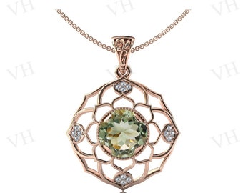 Può includere: Collana con pendente in oro rosa con una grande gemma rotonda verde chiaro al centro, circondata da un design traforato decorativo. Piccole gemme chiare sono incastonate attorno alla pietra centrale. La catena della collana è delicata.