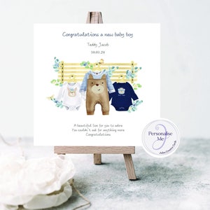 New baby boy personalised card for a special son, grandson, baby boy clothes hung on display card with baby birth date printed on the card