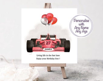 May include: A red race car with black wheels and the number 27 on the side. The car is decorated with red and silver balloons. The text "JAMES" is printed below the number 27. The text "Living life in the fast lane Enjoy your Birthday Son!" is printed below the car. The text "Personalise with Any Name Any Age" is printed in a circle in the upper right corner of the image.