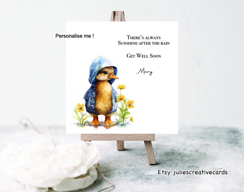 Op de afbeelding: Een aquarel-illustratie van een eendje dat een blauwe regenjas draagt en gele bloemen. De tekst luidt "Er is altijd zonneschijn na de regen. Beterschap Mary."