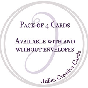 May include: A circular graphic with text that reads "Pack of 4 Cards" and "Available with and without envelopes." The text is in a dark purple color, and the graphic has a light purple swirl design and the words "Julies Creative Cards" in a circular font.