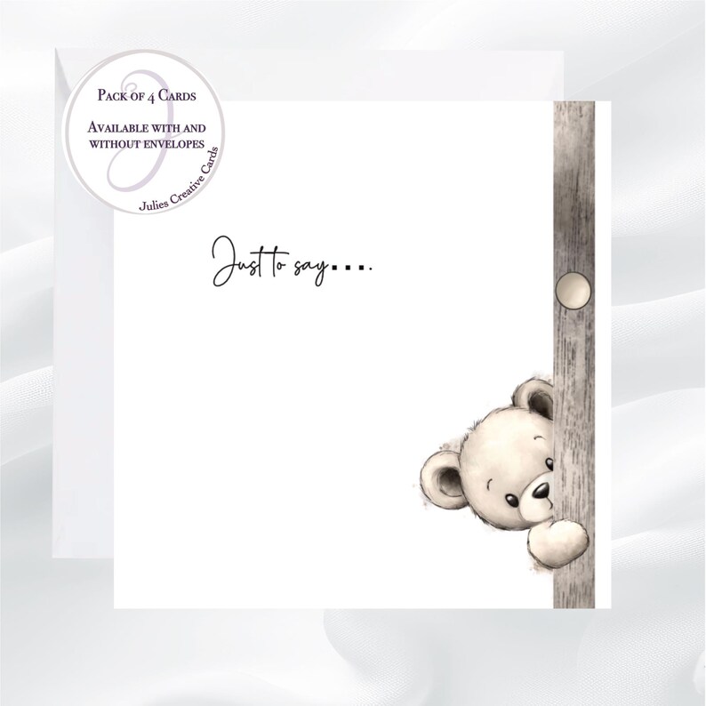 May include: A white greeting card with a watercolor illustration of a teddy bear peeking from behind a wooden post. The card includes the text "Just to say...." and a circular sticker that says "Pack of 4 Cards".