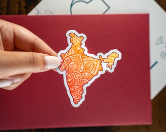 May include: A sticker of India in the shape of the country with an orange and yellow mandala design.