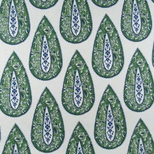 May include: Close-up of a fabric with a repeating paisley pattern. The teardrop-shaped designs are green with intricate leaf and floral details in a darker green and blue. The background is a cream color.