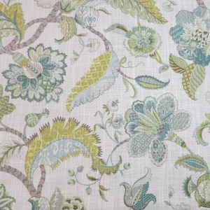 May include: Floral fabric with a repeating pattern of stylized flowers and leaves in shades of green, blue, and yellow on a white background. The design features intricate details and a textured appearance, suitable for home decor.
