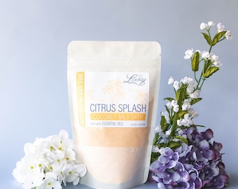 May include: A white pouch with a label that reads "Citrus Splash Coconut Milk Bath Made with Essential Oils". The pouch contains a light orange bath soak.