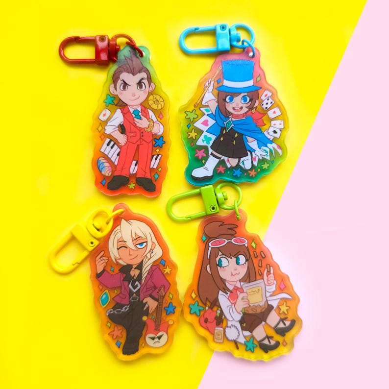 May include: Four colorful keychains featuring anime characters. Each keychain has a different character with a unique design and background. The keychains are made of clear acrylic and have a metal ring for attaching to keys.