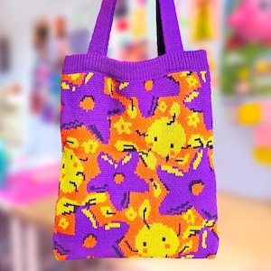 May include: Purple knitted tote bag with a colorful pattern of orange, yellow, and black stars and flowers.