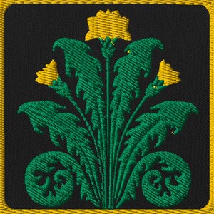 May include: Embroidered patch with a black background and a gold border. The patch features a green floral design with yellow accents. The design includes stylized leaves and flowers, creating a decorative emblem.