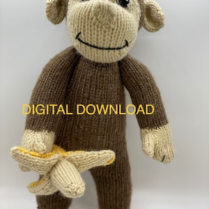 Op de afbeelding: Een bruin gebreid aapje speelgoed dat een gele gebreide banaan vasthoudt. De aap heeft een glimlachend gezicht met zwarte ogen en een zwarte mond. Het speelgoed is gemaakt van zacht garen en is geschikt voor kinderen.