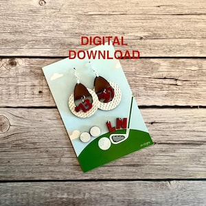 May include: A pair of white golf ball earrings with red numbers and a golf club and golf ball charm. The earrings are on a white card with a green background and the text "DIGITAL DOWNLOAD".