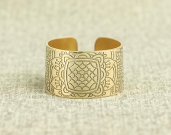 Könnte beinhalten: Ein goldfarbenes Metall-Armband mit einem komplizierten geometrischen Muster.
