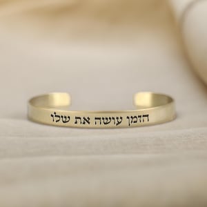 May include: Gold bracelet with the Hebrew inscription "Ha'emek Sh'l'cha Et Shel'o"