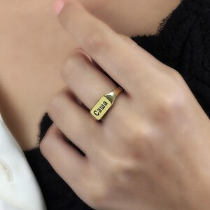 May include: A gold signet ring with the name "Саша" engraved on it.