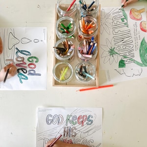 May include: Two children color on a white table with colorful pencils. The table has a set of jars filled with colored pencils and three coloring pages. The coloring pages have the phrases "God loves", "Magnified", and "God keeps his promises".