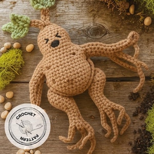 May include: A crocheted, tan-colored Mandrake plant doll with green leaves, black eyes, and a smiling mouth. The doll has arms and legs, and is lying on a wooden surface. A circular logo with the words "CROCHET PATTERN" is in the lower left corner.