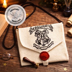 May include: Cream-colored, crocheted shoulder bag featuring the Hogwarts crest in black. The bag has a flap closure with a red crocheted button and a black strap. A round logo with the words "CROCHET PATTERN" is visible.