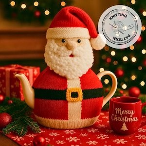 May include: A festive teapot shaped like Santa Claus, with a red knitted body, white beard, and hat. A black belt with a gold buckle accents the design. A red mug with "Merry Christmas" text and a Christmas tree is next to the teapot.