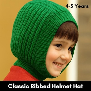 Può includere: Un cappello a casco in maglia a coste verde per bambini. Il cappello copre la testa e il collo, con un'apertura per il viso. Il testo "4-5 anni" è visibile. Il testo "Classic Ribbed Helmet Hat" è visibile.