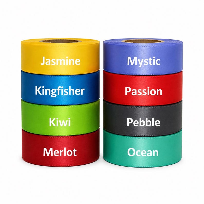 May include: Two stacks of colorful ribbon rolls. The left stack features yellow, blue, green, and red ribbons labeled "Jasmine", "Kingfisher", "Kiwi", and "Merlot". The right stack has blue, red, black, and teal ribbons labeled "Mystic", "Passion", "Pebble", and "Ocean".