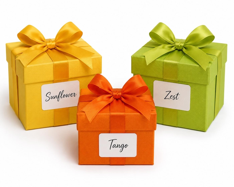May include: Three square gift boxes in yellow, orange, and green, each with a matching satin ribbon bow. The boxes have white labels with the words "Sunflower", "Tango", and "Zest".